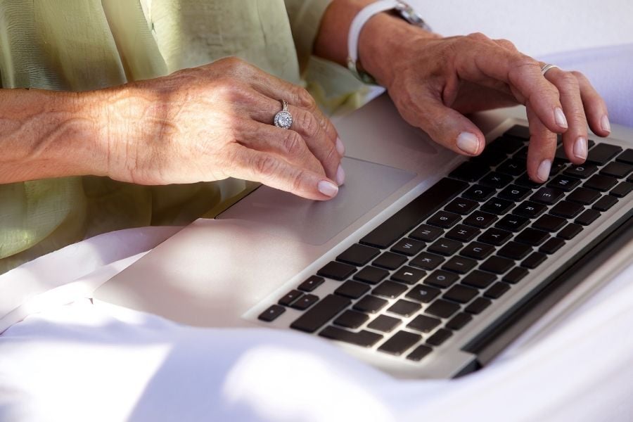 Woman in green shirt types on laptop
