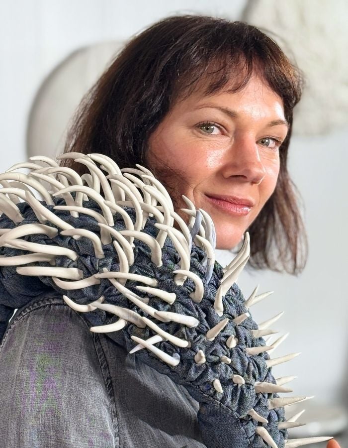 Tina marais holding artwork over her shoulder